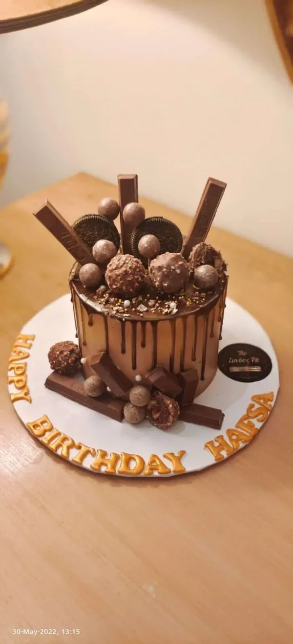 Luxury chocolate cake topped with KitKat, Dairy Milk, and Ferrero – best chocolate cake in Islamabad by Gift Shop Islamabad.